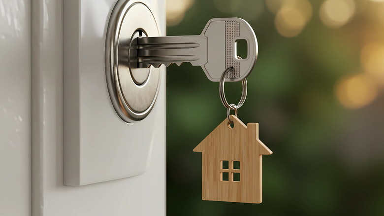 A keychain with a key in a door lock.