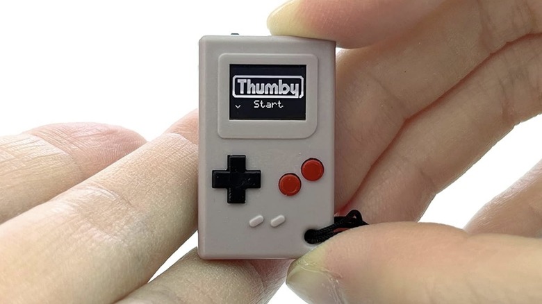 a hand holding the Thumby device