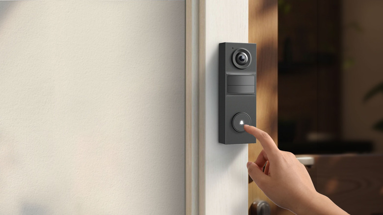 Hand pressing Tapo D205 Video Doorbell Mini