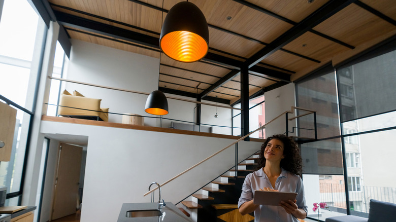 Person controlling smart lights via tablet.