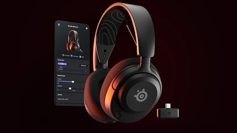 A pair of black SteelSeries Arctic Nova 5X Wrieless headphones standing against a black backdrop, the headphones have a slight orange glow as they sit next to their USB dongle and a screenshot of the accompanying app