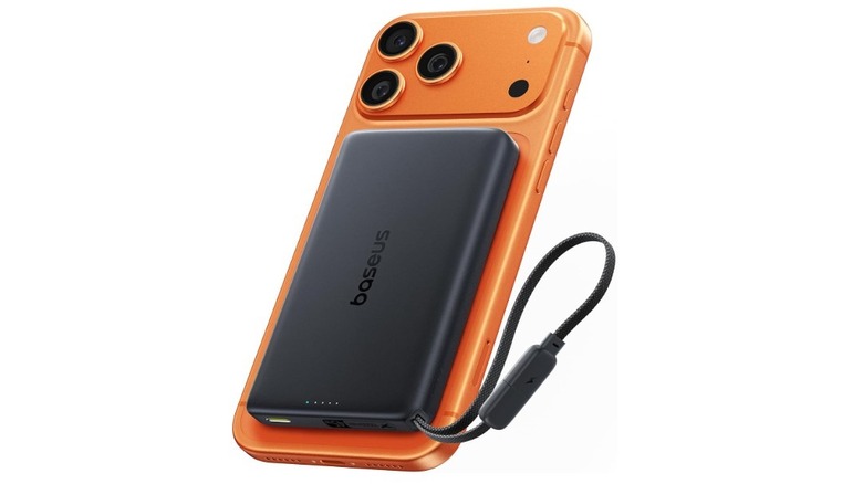 Baseus Picogo AM52 MagSafe Power Bank attached to the back of an orange iPhone 17 Pro Max.