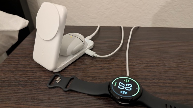 Belkin Qi2.2 25 W Wireless 2-in-1 Foldable Fast Charging Station charging a pair of earbuds and a smartwatch.
