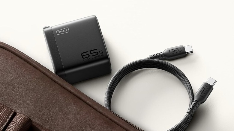 Iniu 65 W wall charger with USB-C cable kept beside a bag.