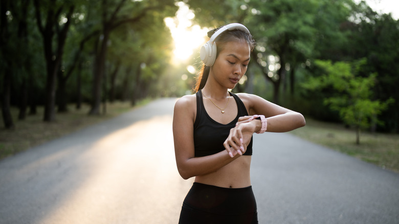 person checking fitness tracker on run