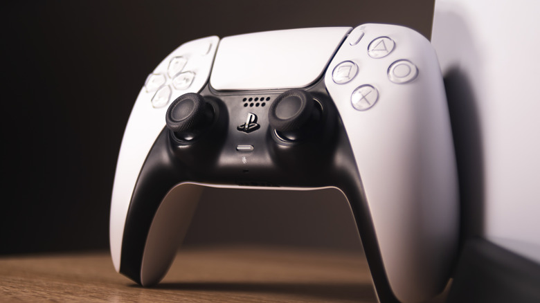 close-up of controller for PlayStation 5 resting against console on a table