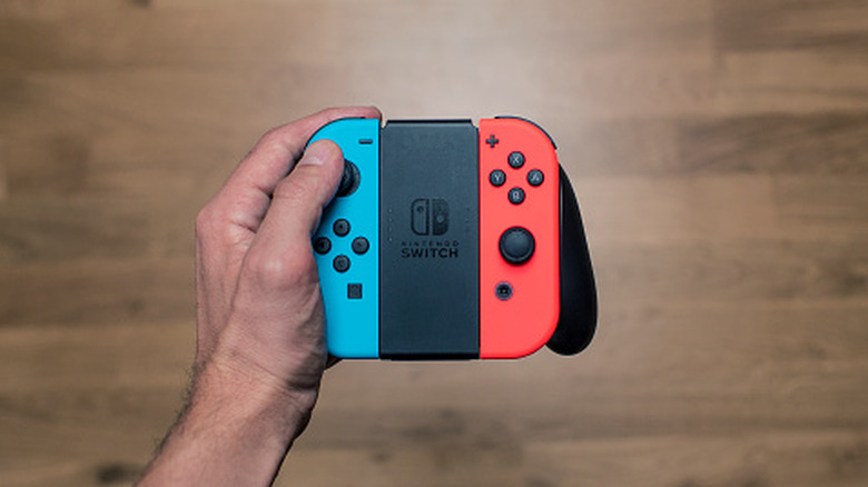 Hand holding Nintendo Switch Joy-Con controllers