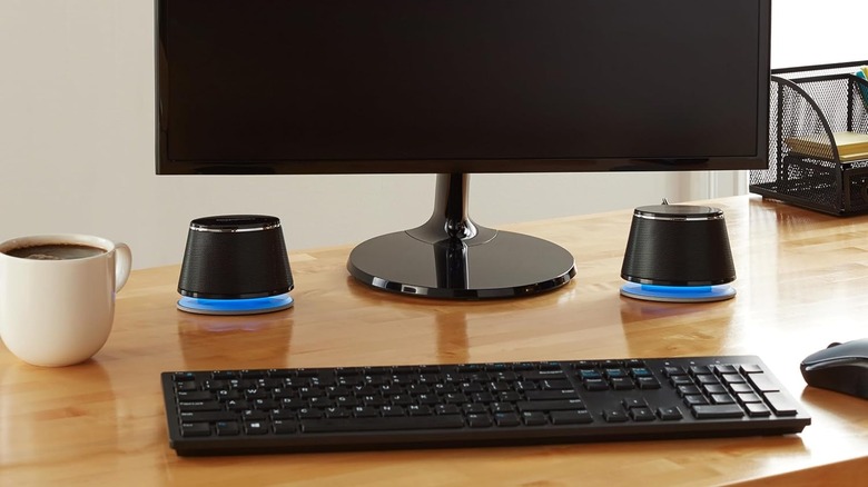 The Amazon Basics Stereo 2.0 Speakers on a desk next to a monitor.