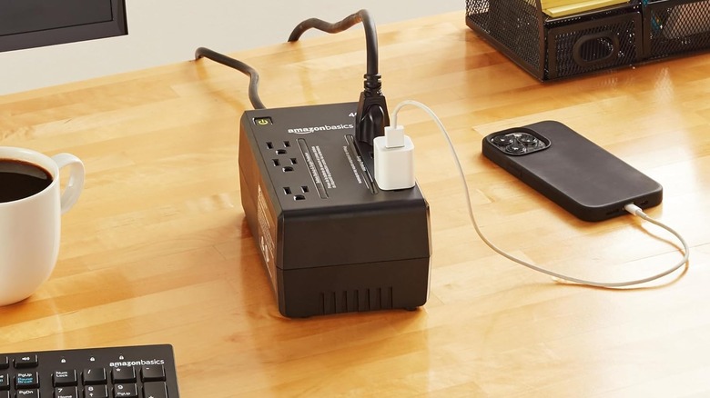 The Amazon Basics UPS on a desk next to a PC and phone.