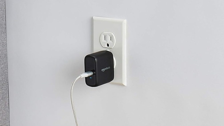 The Amazon Basics wall charger plugged into an outlet.