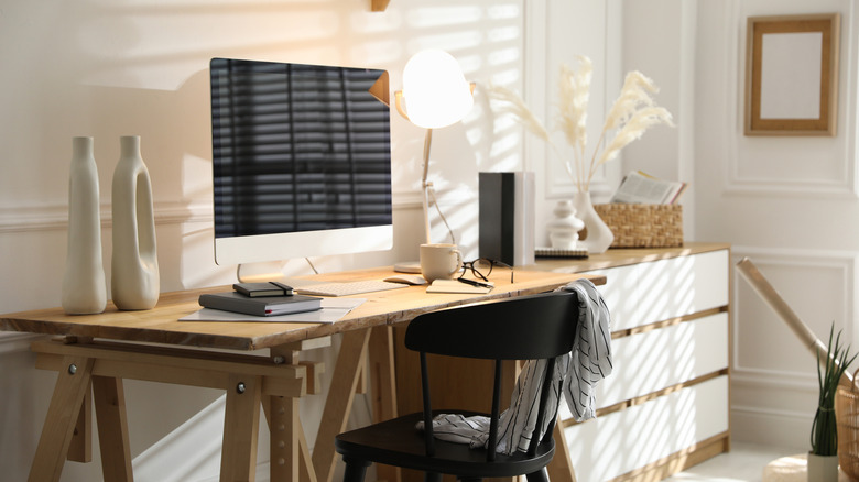 A brown office desk sitting in a white room