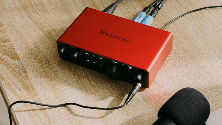 A red Focusrite Scarlett 2i2 Fourth-Gen USB-C Audio Interface sitting on a table