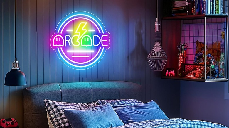 The Basaneon Gamer Arcade LED Neon Sign adorned to a wall just above a bed