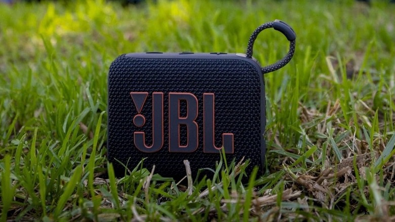 The JBL Go 4 Bluetooth speaker outdoors, on grass.