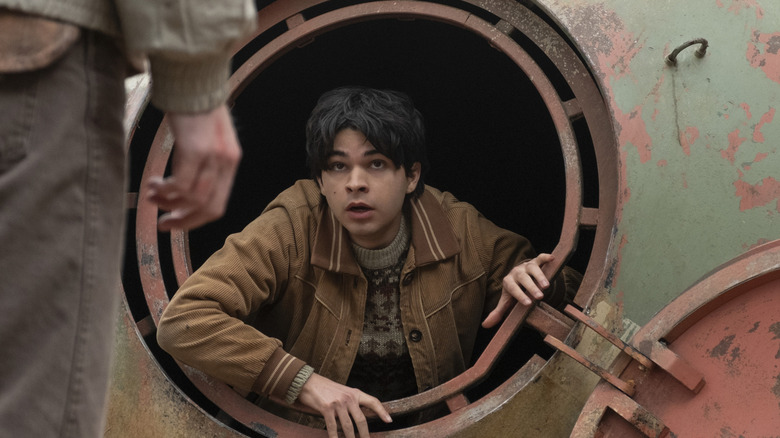 Jakob climbing out of a rusted underground tank and looking up in Tales from the Loop (2020)