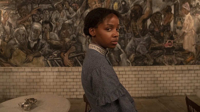 Cora looking back in front of mural in The Underground Railroad (2021)