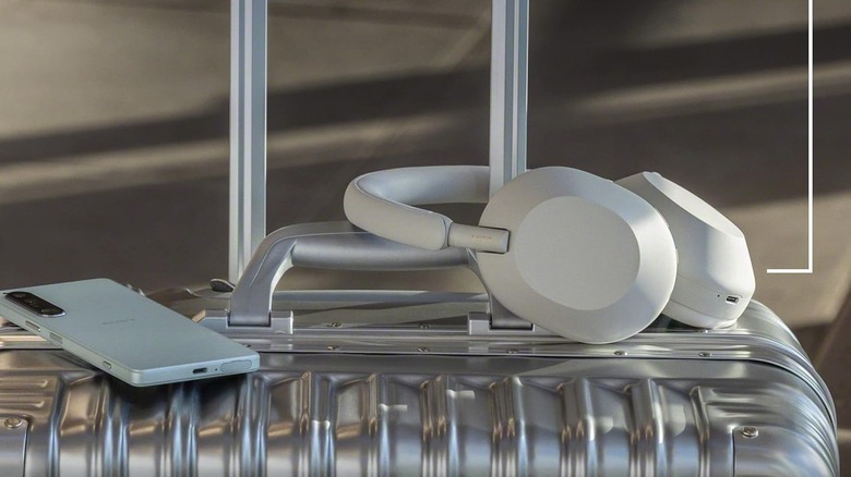 Sony WH-XM10005 ANC wireless headphones resting atop luggage.