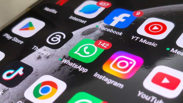 a smartphone showing a list of installed apps and notifications on a home screen