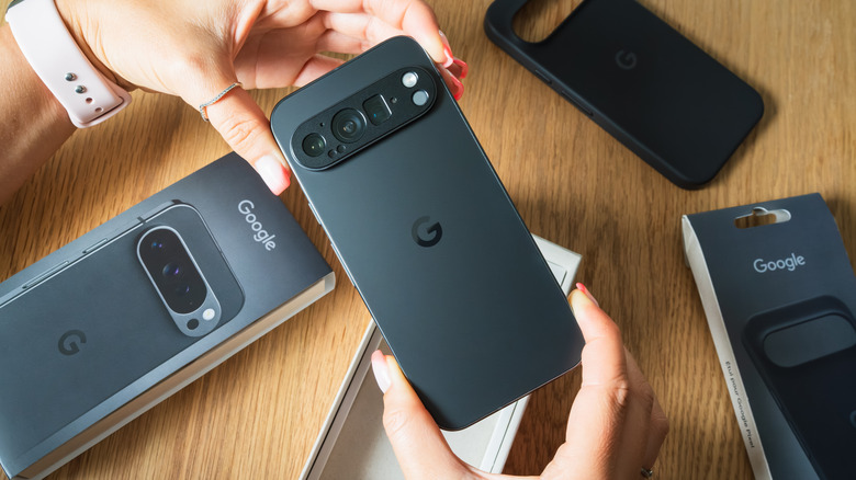 A pair of hands holding a black Google device at both ends with their thum and index fingers