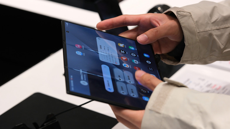 A person using a fully unfolded Samsung Galaxy Z Trifold
