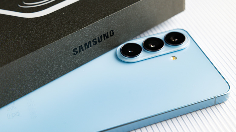 Samsung Galaxy S26 lying beside its box with the rear cameras visible.