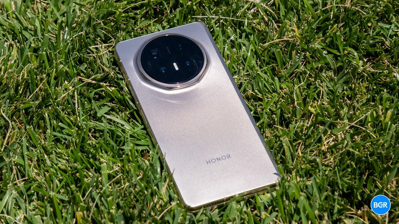 A folded Honor Magic V6 foldable phone placed on grass