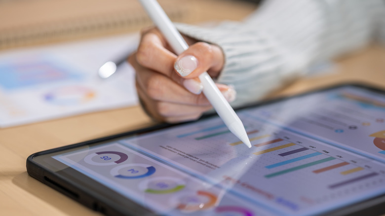 Person using a stylus to interact with their tablet