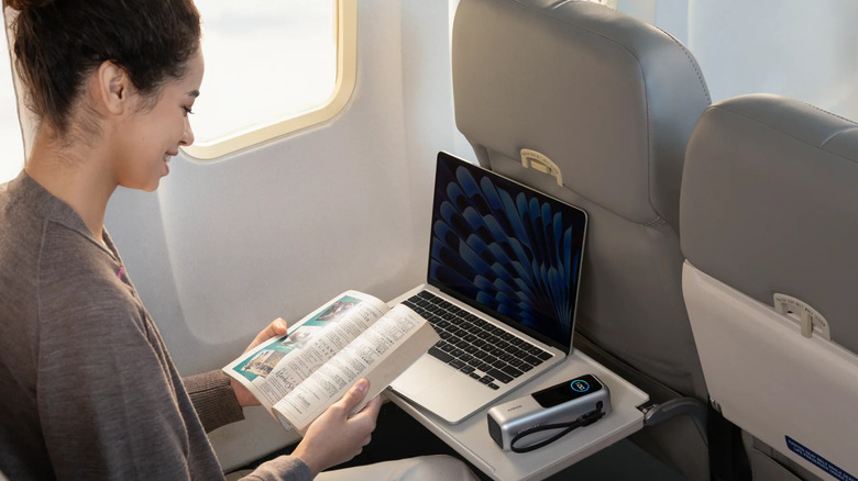 Person on a flight charging laptop with Anker Laptop Power Bank