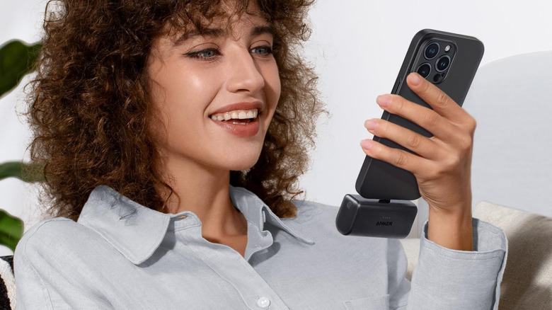 Person holding phone connected to Anker Nano Power Bank