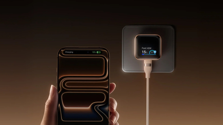 Hand holding iPhone 17 while connected to Anker Nano Charger 45W