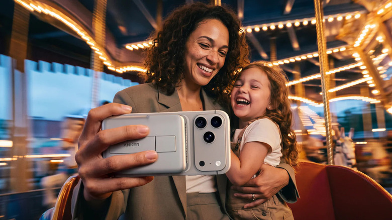Person riding carousel while holding iPhone with MagGo 2 Pro at the back