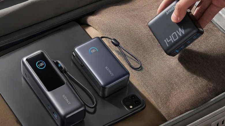 A man putting several Anker accessories in a suitcase