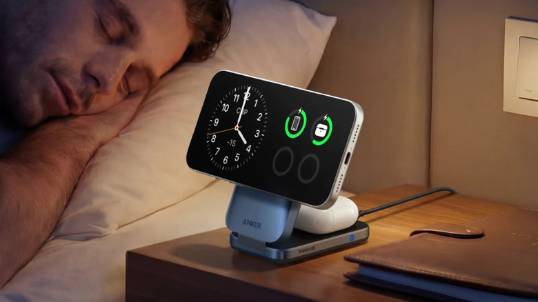 An Anker Prime Foldable Wireless Charging Station charging a iPhone, AirPods, and an Apple Watch simultaneously on a bedside table