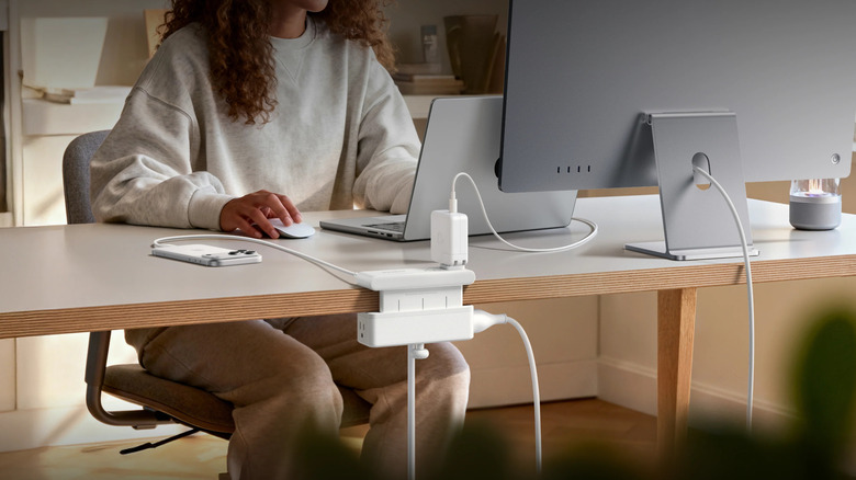 A woman using a Nano Power Strip Clamp on an office desk