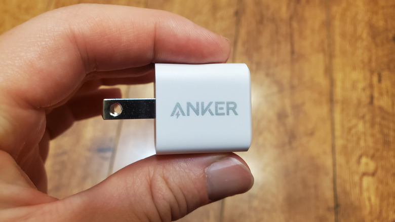 A person holding an Anker USB charger