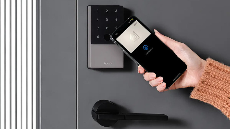 A person using an iPhone to unlock a door with a smart lock.