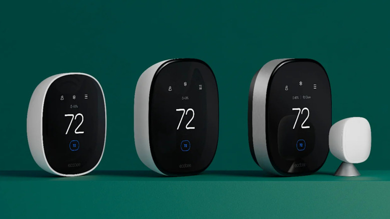 Three smart thermostats on a green background