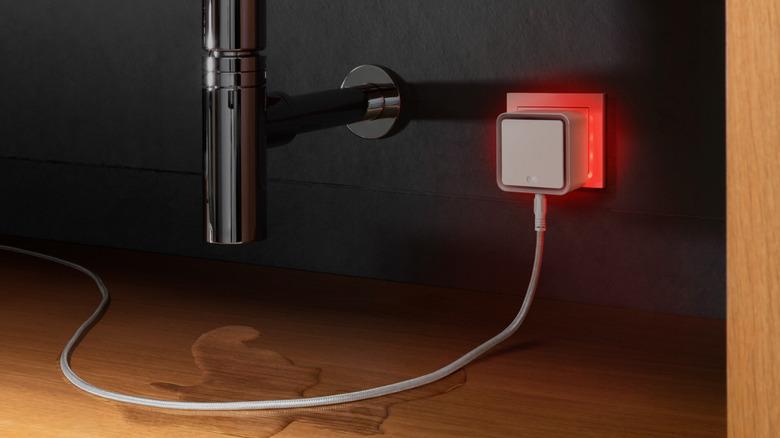 A water leak sensor and wire plugged into a wall outlet
