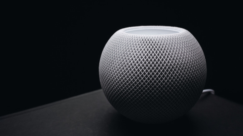 An Apple HomePod speaker on a black background