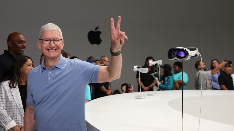 Apple CEO Tim Cook stands next to the new Apple Vision Pro headset is displayed during the Apple Worldwide Developers Conference