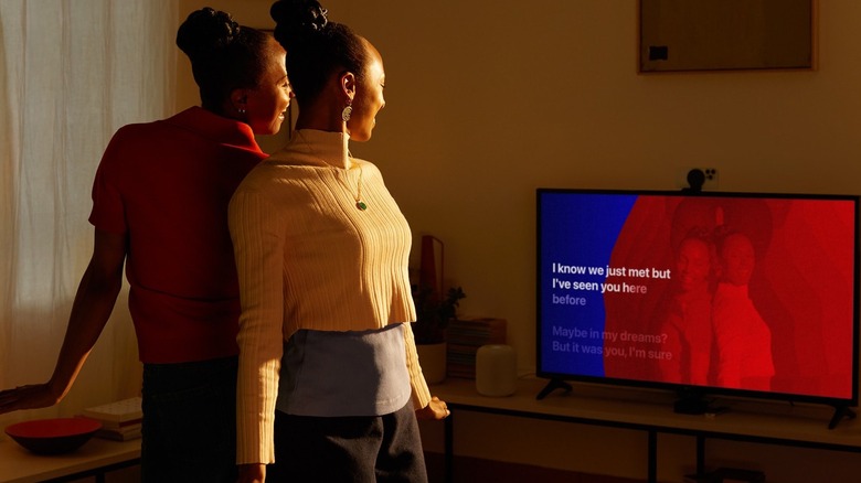 Two women enjoying Apple Music Sing on a TV