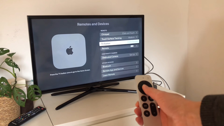 TV showing Apple TV Settings with TV Button option