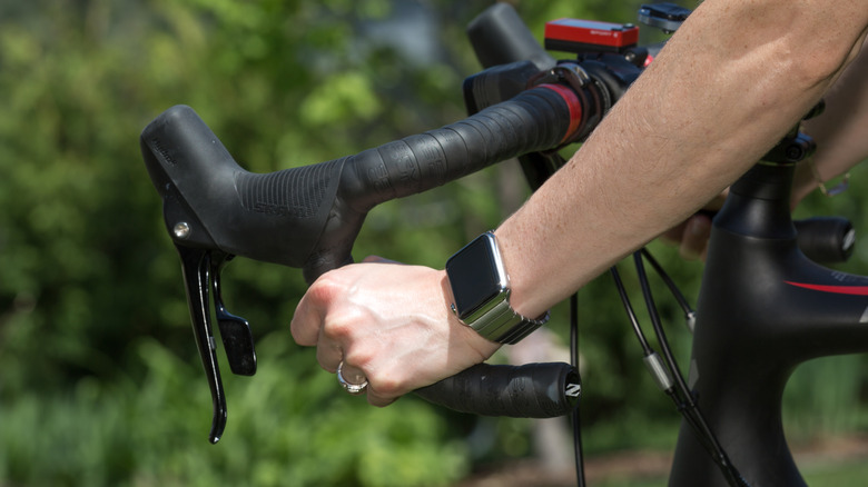 Woman wearing a 42mm Stainless Steel Apple Watch with Link Bracelet on a bicycle