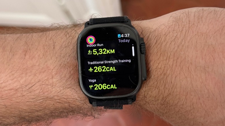 An Apple Watch on a man's wrist showing several workouts completed