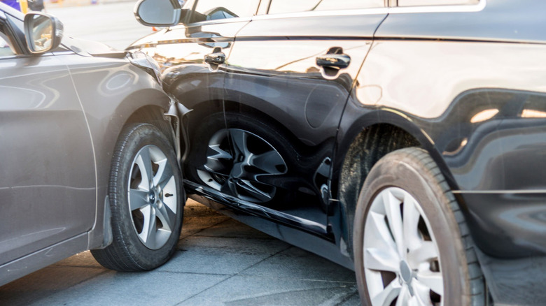 Close-up of a gray car hitting a black car
