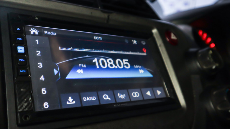Close-up of a car's infotainment system showing FM radio playback