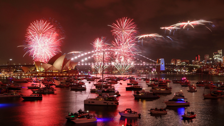 boats in water with fireworks in the background