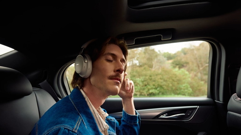 A man wearing a pair of Bose headphones in a car.