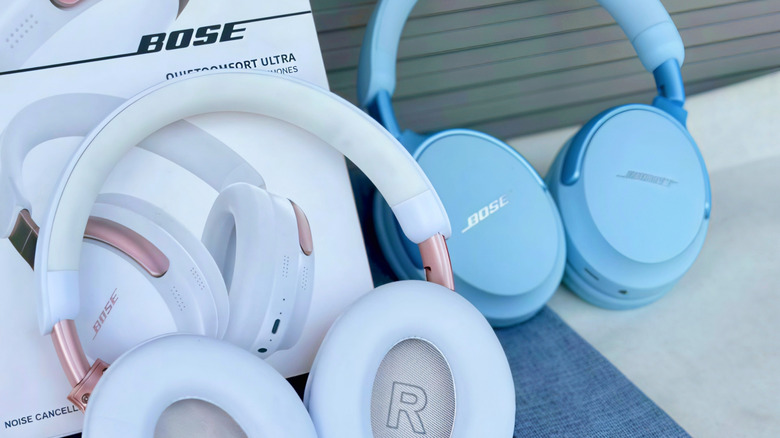 Two pairs of Bose QuietComfort Ultra Headphones placed beside one of the product boxes.