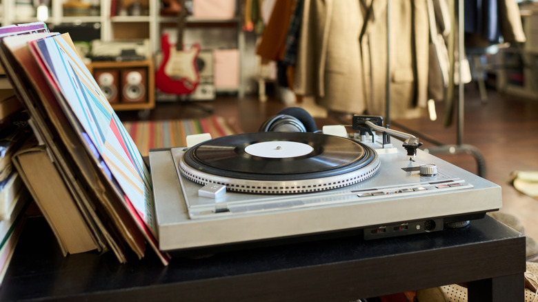 A turntable with assorted vinyl records on a table